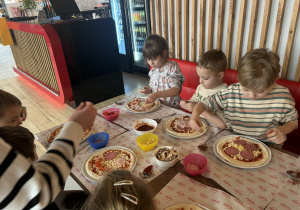 Dzieci dobierają składniki do swojej pizzy