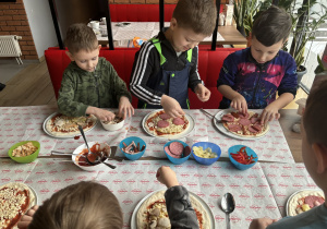 Dzieci dobierają składniki do swojej pizzy