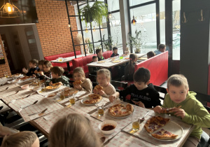 Dzieci spożywają pizzę