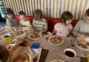 Dzieci dobierają składniki do swojej pizzy