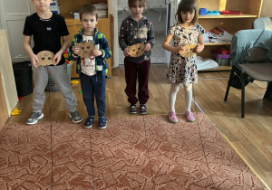 Dzieci nawijają sznurek z myszką na głowę kota