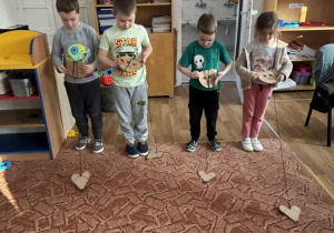 Dzieci nawijają sznurek z myszką na głowę kota