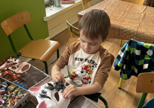 Dzieci ozdabiają maskę kota