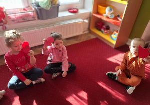 Dzieci pokazują połówki serc