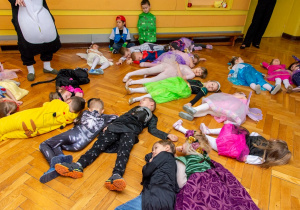 Dzieci leżą na podłodze udając, że śpią