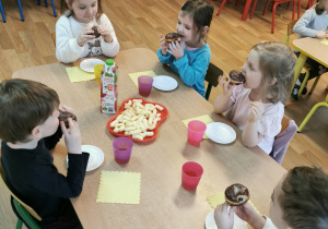 Dzieci jedzą pączki