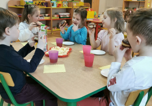 Dzieci jedzą pączki