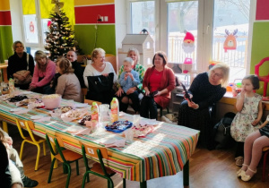 Dzieci siedzą wspólnie z dziadkami