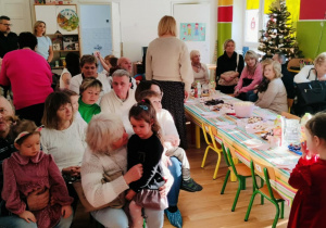 Dzieci siedzą wspólnie z dziadkami