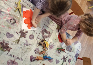 Dzieci wykonują w glinie odciski dinozaurów