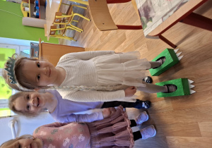 Dziewczynka prezentuje "dinozaurowe buty" wykonane z pudełek