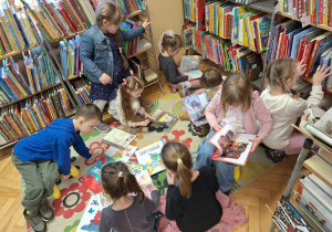 Grupa dzieci ogląda książki w kąciku czytelniczym