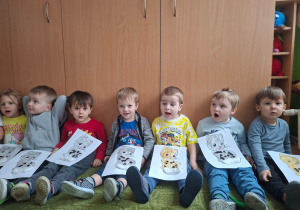 Dzieci pozują do zdjęcia trzymając wykonane prze siebie prace