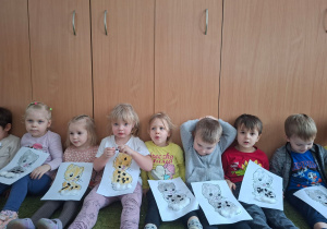 Dzieci pozują do zdjęcia trzymając wykonane prze siebie prace