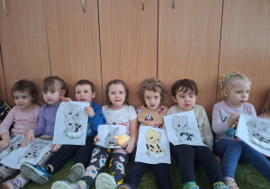 Dzieci pozują do zdjęcia trzymając wykonane prze siebie prace