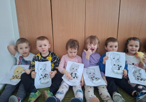 Dzieci pozują do zdjęcia trzymając wykonane prze siebie prace