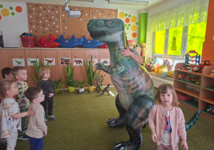 Dzieci słuchają opowieści o dinozaurze