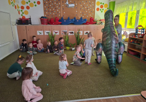 Dzieci obserwują dinozaura