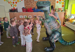 Dzieci obserwują dinozaura