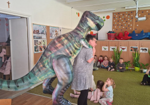 Dzieci patrzą, jak dinozaur wchodzi do klasy