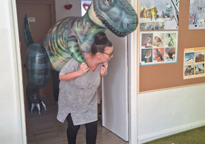 Dzieci patrzą, jak dinozaur wchodzi do klasy