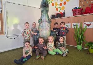Dzieci pozują do zdjęcia z dinozaurem