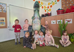 Dzieci pozują do zdjęcia z dinozaurem