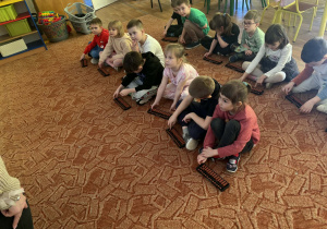 Dzieci siedzą przed liczydłami zwanymi abakus