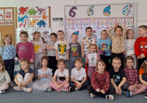 Dzieci stoją na dywanie i pozują do zdjęcia z Nadią