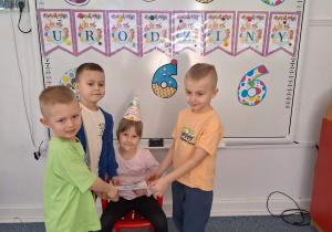 Chłopcy wręczają Michalinie dyplom urodzinowy