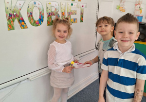 Dwóch chłopców wręcz dziewczynce upominek