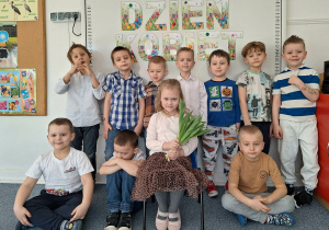 Dziewczynka pozuje do zdjęcia z chłopcami na tle dekoracji