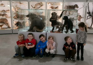 Grupa dzieci stoi przy eksponatach w muzeum