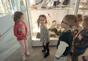 Grupa dzieci ogląda eksponaty w muzeum