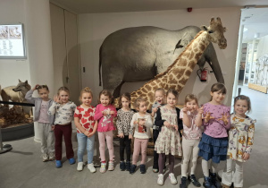 Grupa dzieci stoi przy eksponatach w muzeum