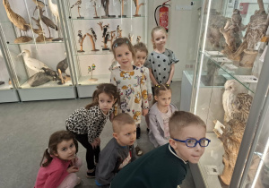 Grupa dzieci ogląda eksponaty w muzeum