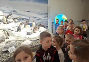 Grupa dzieci ogląda eksponaty w muzeum