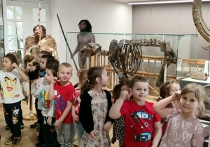 Grupa dzieci stoi przy eksponatach w muzeum