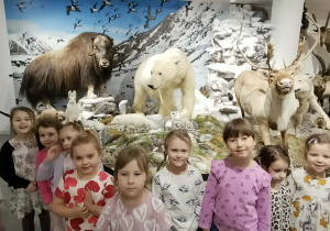 Grupa dzieci stoi przy eksponatach w muzeum