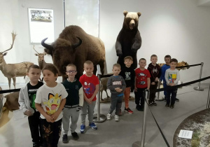 Grupa dzieci ogląda eksponaty w muzeum