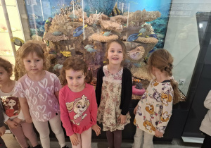 Grupa dzieci stoi przy eksponatach w muzeum