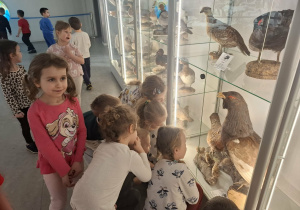 Grupa dzieci ogląda eksponaty w muzeum