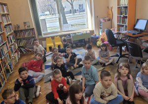 Dzieci słuchają Pani podczas zajęć w bibliotece