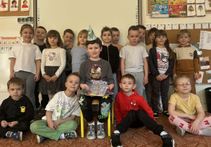 Solenizant w czapeczce urodzinowej z grupą kolegów