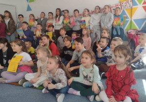 Uczniowie pozują do zdjęcia z przedszkolakami