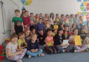 Uczniowie pozują do zdjęcia z przedszkolakami