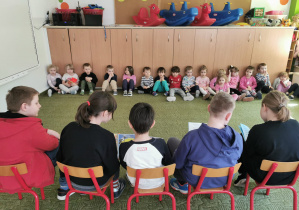 Przedszkolaki słuchają wierszy czytanych przez uczniów