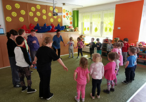 Przedszkolaki bawią się w kole z uczniami