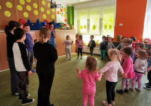 Przedszkolaki bawią się w kole z uczniami