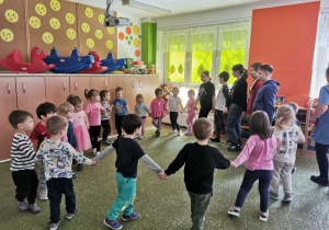 Przedszkolaki bawią się w kole z uczniami